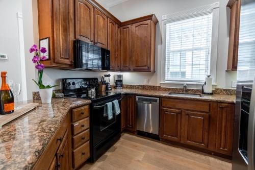 a kitchen with wooden cabinets and black appliances at American Shoal Light Suite in Key West