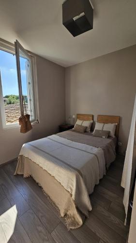 une chambre avec un grand lit et une fenêtre dans l'établissement Appartement PETIT SAINT GIMER, à Carcassonne
