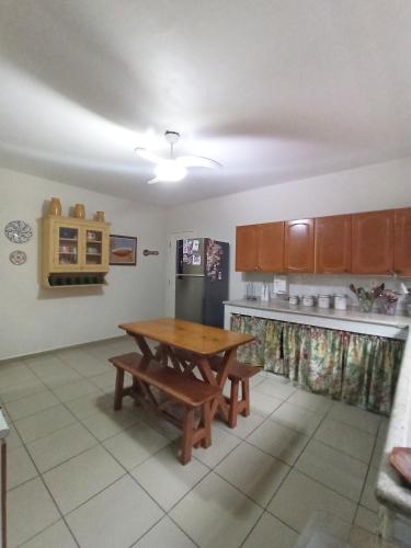 a kitchen with a wooden table in the middle of it at Casa do Bosque, 367 in Rio das Ostras