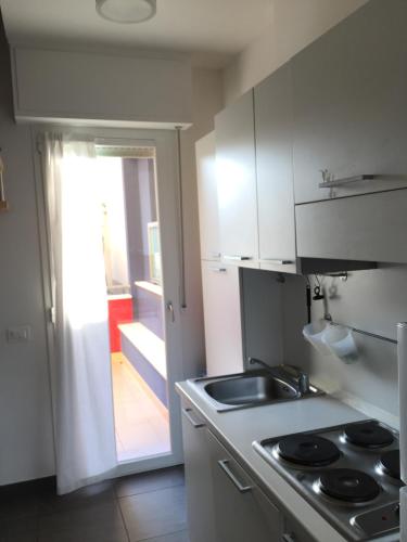 a kitchen with a stove and a sink and a door at Residence La Nave in Senigallia