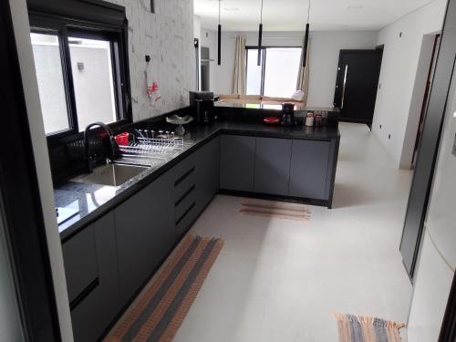 - une cuisine avec comptoirs noirs et évier dans l'établissement Nosso Recanto 2 Próximo aos Pontos Turísticos, à Foz do Iguaçu