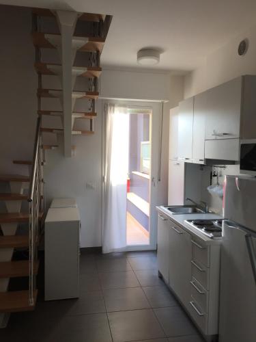 a kitchen with a staircase leading to a door at Residence La Nave in Senigallia