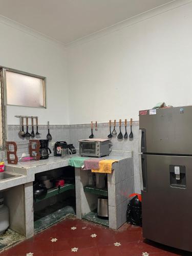 a kitchen with a counter with a stove and a refrigerator at Casa Bienestar in Guatemala