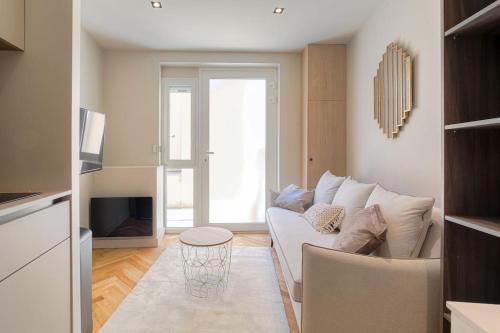 un salon avec un canapé blanc et une télévision dans l'établissement Bright and comfortable studio, Saint-Didier, à Lyon