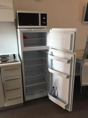 an open refrigerator with a microwave on top of it at Residence La Nave in Senigallia