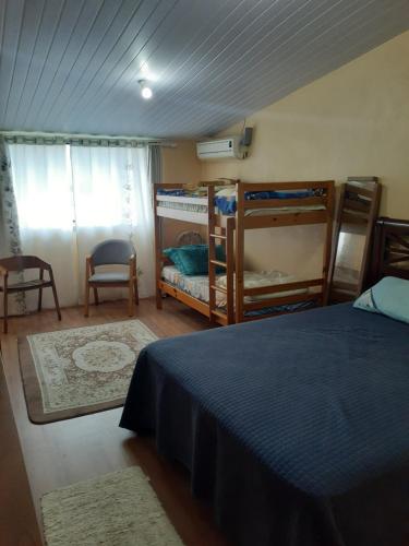 a bedroom with a bed and two bunk beds at Kitinete Ubatuba vista mar in São Francisco do Sul