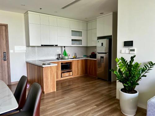 a kitchen with wooden floors and white cabinets at Căn 2 ngủ Landmark 2 Ecopark view hồ đẹp in HÆ°ng YÃªn