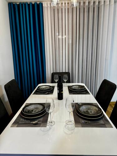 a table with plates and wine glasses on it at BISI penthouse in Skopje