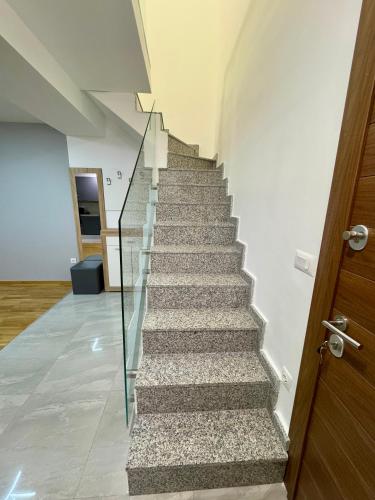 a staircase in a house with a glass railing at BISI penthouse in Skopje