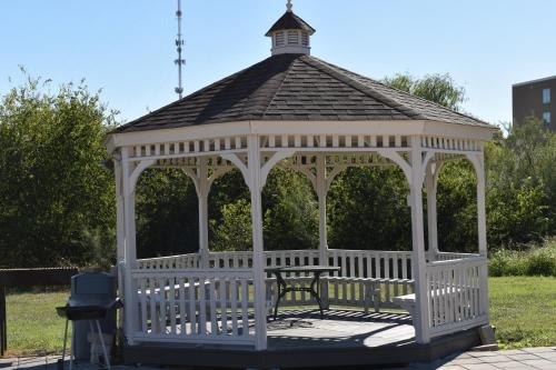 a white gazebo with a bench in a park at Studio 6 Suites Brenham, TX in Brenham