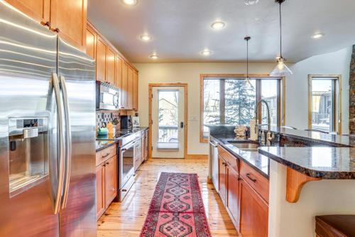 a large kitchen with wooden cabinets and stainless steel appliances at Dtwn Frisco Home with Mtn View, 11 Mi to Ski Breck! in Frisco