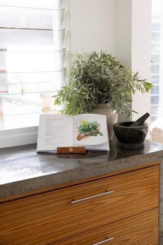 a book sitting on top of a counter with a plant at THE BEACH HAVENS - Haven Oceana in Emerald Beach