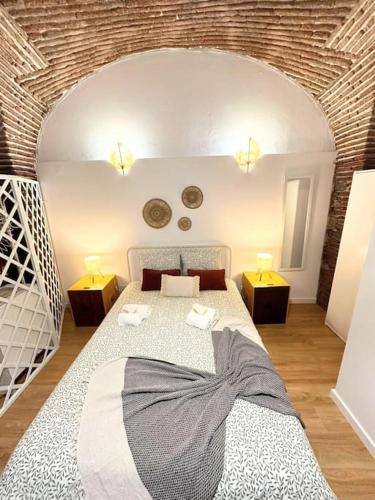 a bedroom with a bed with two tables and two lamps at Casa D'Arriaga in Beja