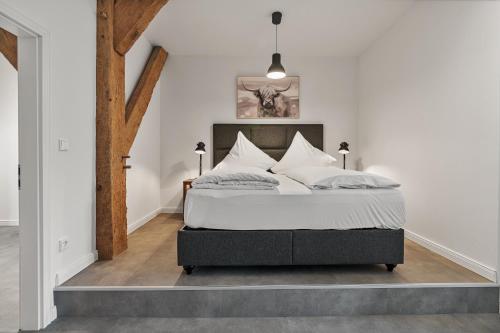 a bedroom with a bed with white sheets and pillows at Tofthof dree in Westerhever