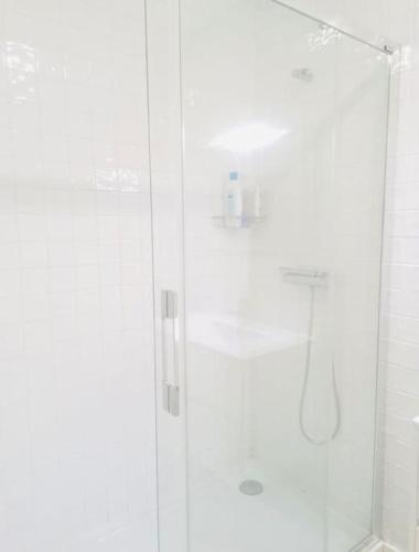 a white shower with a glass door in a bathroom at Cantinho do Fórum IV in Aveiro