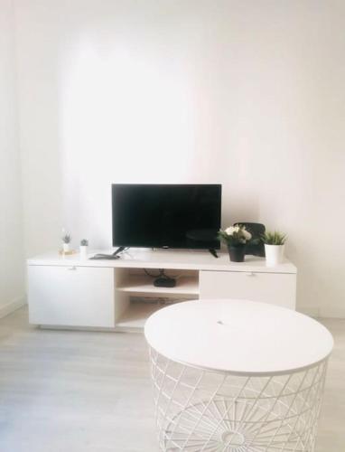 a white living room with a tv on a white entertainment center at Cantinho do Fórum IV in Aveiro