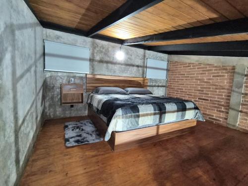 a bedroom with a bed and a brick wall at Cabañas pareja Tapalpa LUNA AZUL in Tapalpa