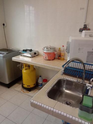 a kitchen with a sink and a counter top at ARUWDA Homestay in Ipoh