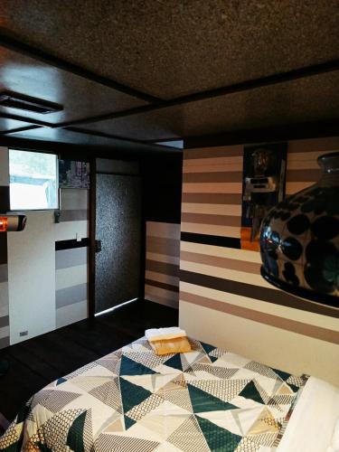a bedroom with a bed in a room with striped walls at Cabaña 79 Papallacta Alpina in Papallacta