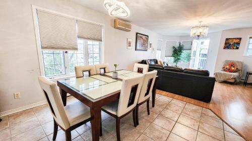 a dining room with a table and chairs and a couch at Condo de charme familial in Brossard