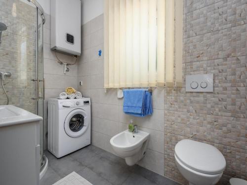 a bathroom with a toilet and a washing machine at Apartment in Kukci with Heated Pool in Kukci