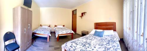 une chambre avec trois lits dans une pièce dans l'établissement DCampos Lodge, à Oxapampa