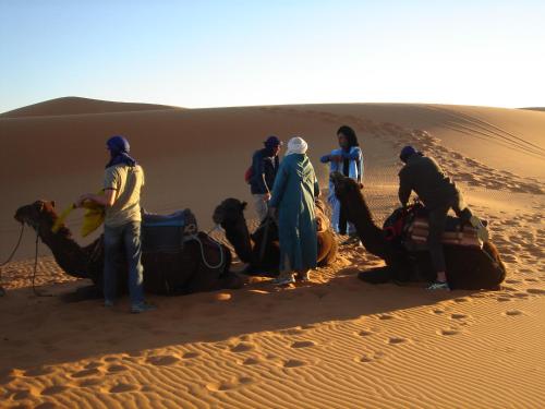 a group of people standing in the desert at Riad Dar Poublanc in Merzouga