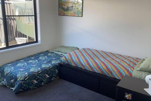 a small bedroom with a bed with a bedskirtspectspectspectspects at 15mins to Mooloolaba Beach opposite Conservation! in Palmview