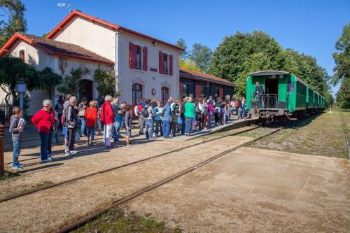 a group of people waiting to board a green train at Luxurious villa with private pool in Salles