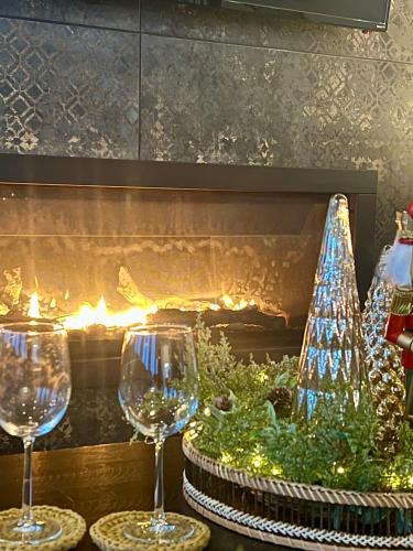 two wine glasses and a christmas tree in front of a fireplace at The View suites and breakfast in Triton, Newfoundland in Pilleyʼs Island