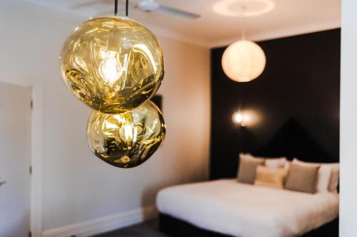 a bedroom with a gold chandelier and a bed at The White Swan Hotel in Greytown