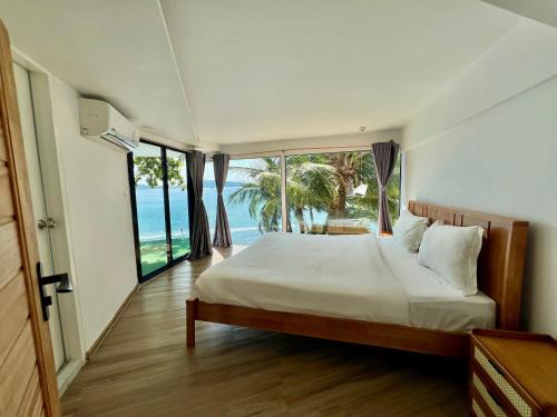 a bedroom with a bed with a view of the ocean at patong sunset villa Phuket in Patong Beach