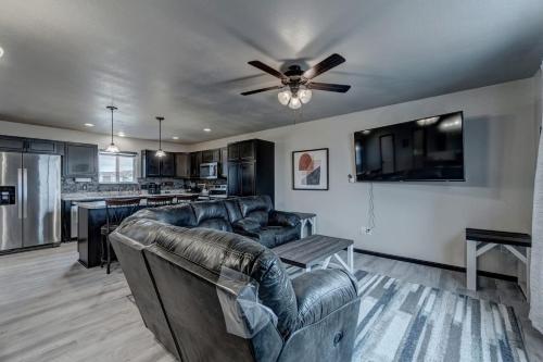 a living room with leather furniture and a ceiling fan at Mini-Rushmore, Lots of Street Parking! in Rapid City