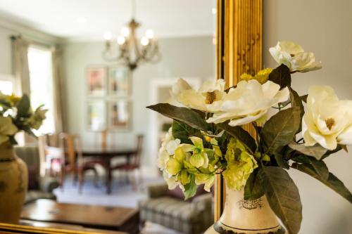 a vase filled with white flowers in front of a mirror at The White Swan Hotel in Greytown
