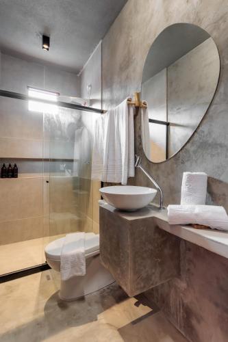 a bathroom with a sink and a toilet and a mirror at Pousada Oribá Chalé Boutique Milagres - AL in São Miguel dos Milagres