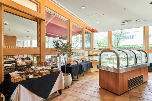 a restaurant with tables in a room with large windows at THE GLOBAL VIEW Nagasaki in Nagasaki