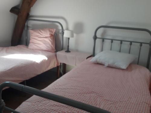 two twin beds in a room with at Spacieuse maison près du Mans avec jardin, idéale pour séjours pro, 4 chambres, Wi-Fi, parking - FR-1-410-330 in Écommoy
