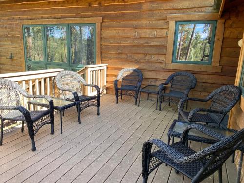 a group of chairs on a porch of a cabin at Black Hills Nature Retreat, Centrally Located in Keystone