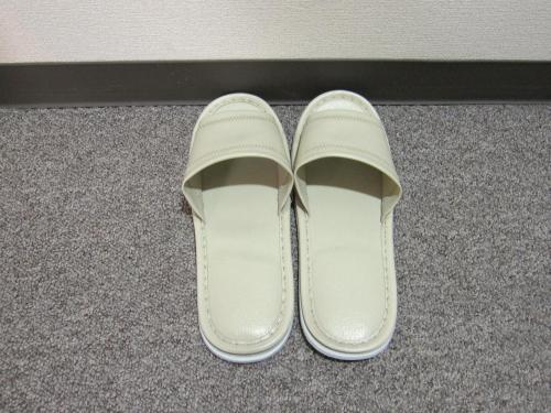 a pair of white shoes sitting on the floor at Toyohashi Station Hotel in Toyohashi