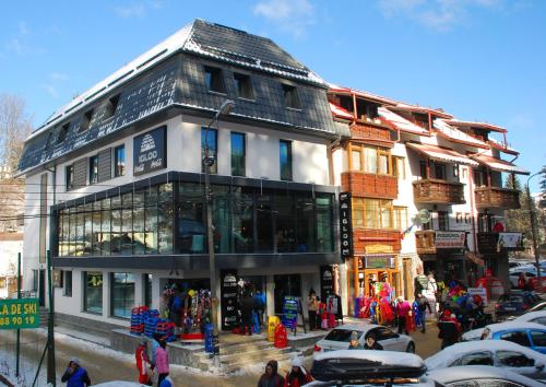 a building on a street with a crowd of people at Camere de Inchiriat IGLOO in Predeal