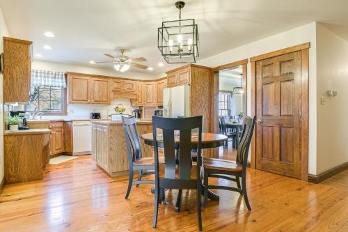a kitchen with wooden cabinets and a table and chairs at 4 Mi to the Amish Village Spacious Home with Deck! in Ronks