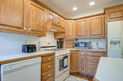 a kitchen with wooden cabinets and white appliances at 4 Mi to the Amish Village Spacious Home with Deck! in Ronks