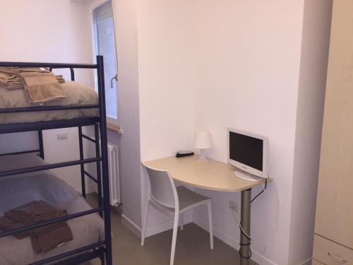 a room with a desk with a computer and a bunk bed at Residence La Nave in Senigallia
