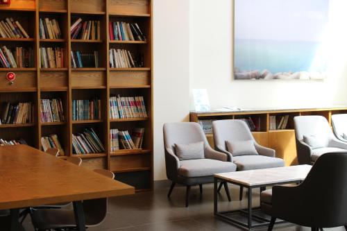 a library with chairs and tables and bookshelves at The Grand Sumorum in Seogwipo