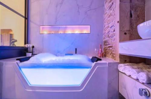 Cette chambre comprend une salle de bains pourvue d'une grande baignoire. dans l'établissement Cosy Love, à Saint-Alban-de-Roche