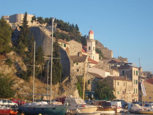 un grupo de barcos estacionados en un puerto deportivo con una ciudad en Ana Apartment, en Šibenik