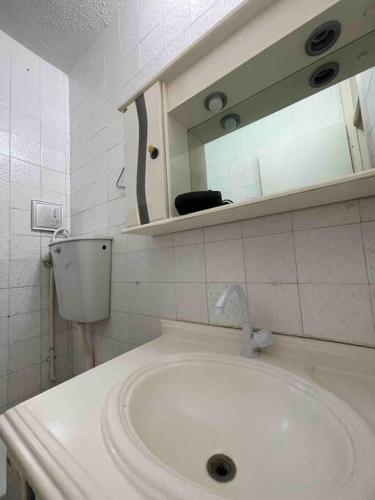 a bathroom with a sink and a mirror at Condomínio Perto da Praia in Cabo Frio