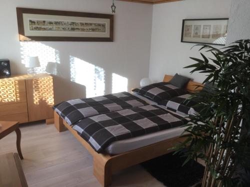 1 dormitorio con cama a cuadros en blanco y negro en Ferienwohnung Milchgaessli en Frutigen