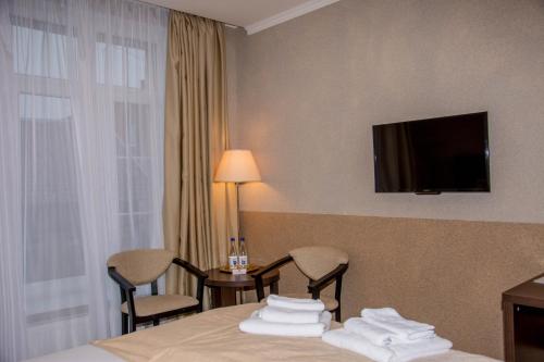 een hotelkamer met een bed en een televisie aan de muur bij Eliza Inn in Zelenogradsk