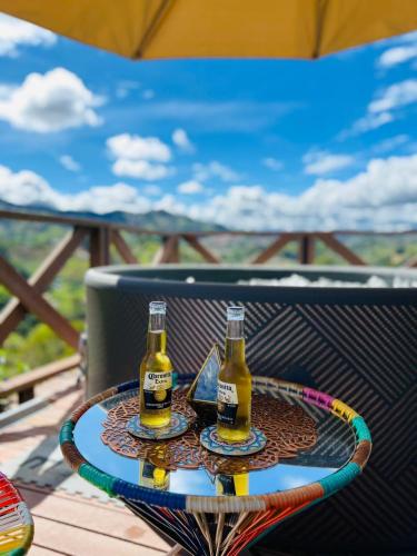 two bottles of beer sitting on a table at Eco Lodge Glamping in Guatapé